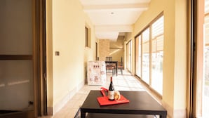 A hotel corridor with a dining area, a bottle of wine, and a red napkin on a table. - Spacious Family Apartment in Pigneto  (Rome)