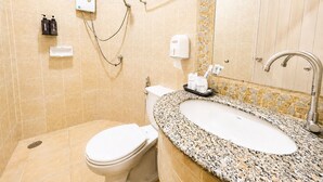 Un baño con inodoro, lavamanos, ducha y secador de manos.