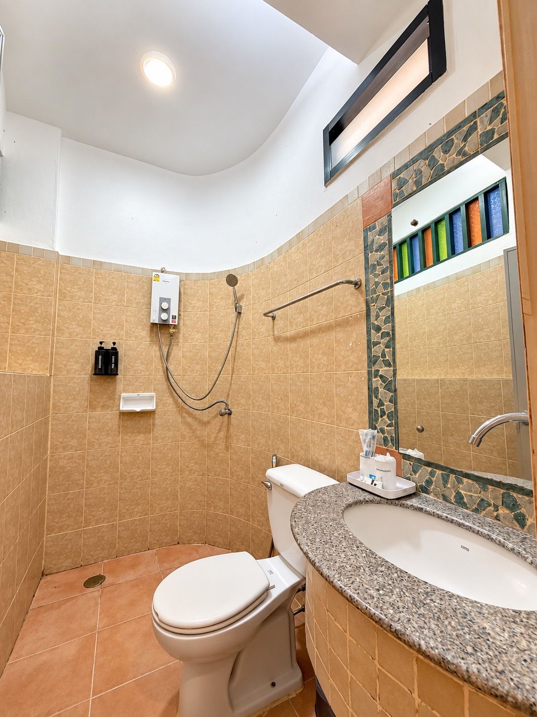A bathroom with a toilet, sink, and shower.