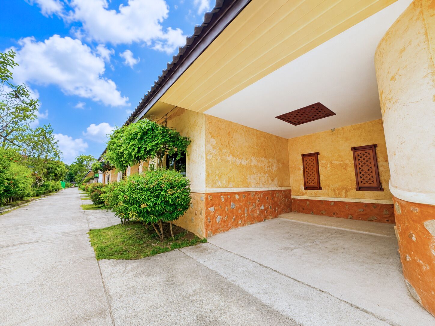 A building with a covered walkway, stone walls, and a clear sky.
