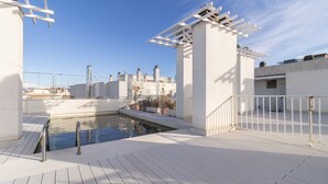 Un área de piscina en la azotea con vistas despejadas del paisaje urbano al fondo.