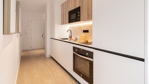 Una cocina moderna con microondas, horno y espacio para el desayuno.