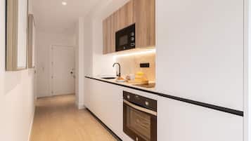 Een moderne keuken met een magnetron, oven en een ontbijtgedeelte.