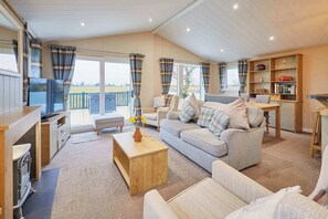 A cozy living room with a sofa, a coffee table, and a television. - Host & Stay | Portland One (Low Gate)