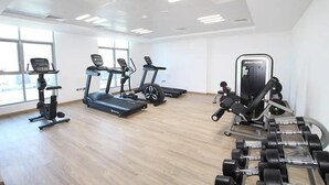 Un gimnasio con cintas de correr, elípticas y pesas sueltas.