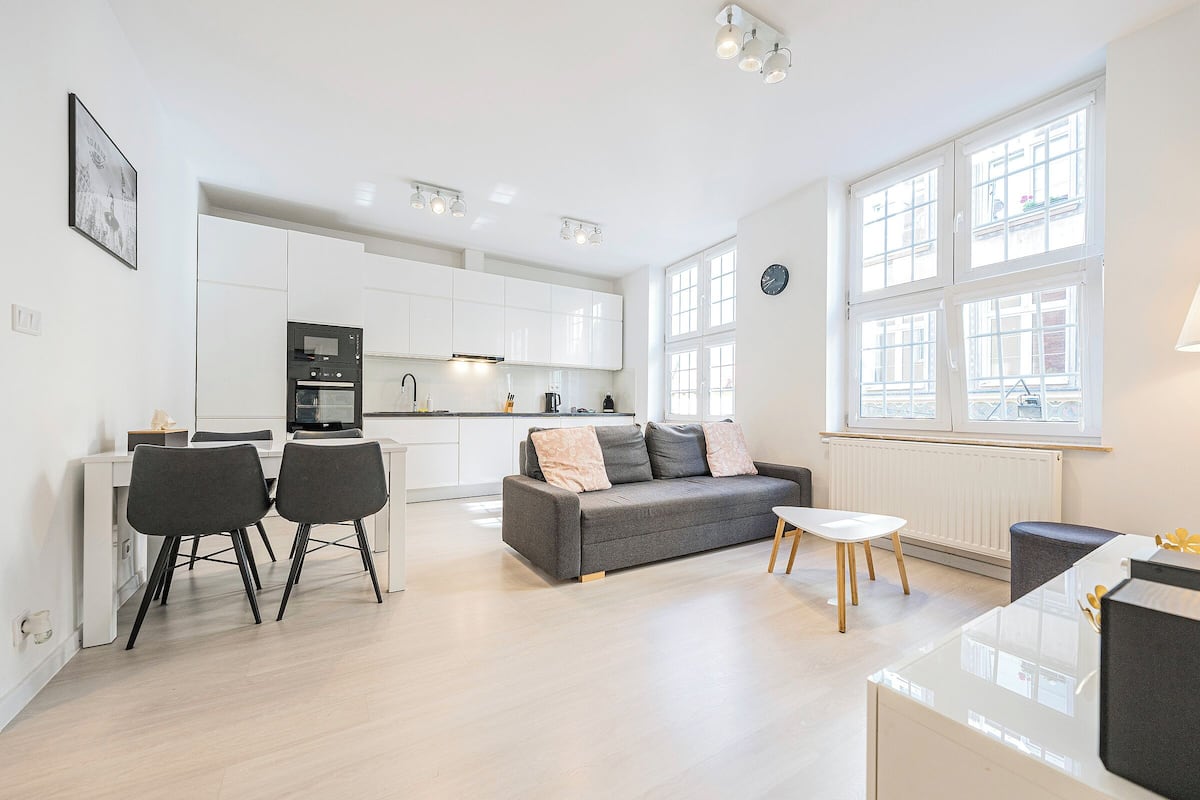A modern apartment with a kitchen, dining area, and living room.