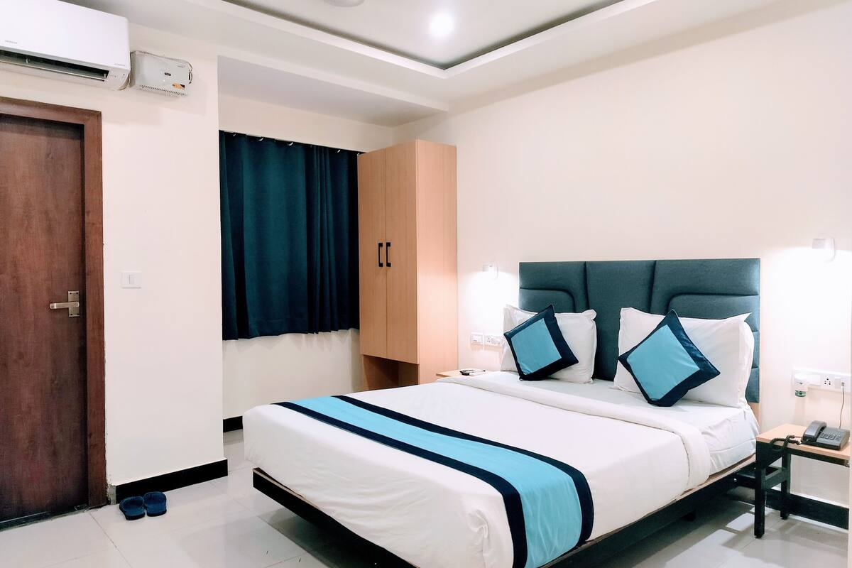 Habitación de hotel ordenada con cama, mesita de noche y armario.