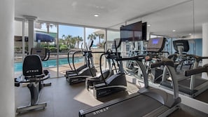 A gym with treadmills, ellipticals, and a pool area visible through glass walls. - NEW! Terrace at Pelican Beach 1503 (Destin)