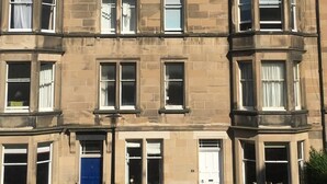 A multi-story building with a traditional architectural style, featuring a corner turret and multiple windows. - Traditional Victorian Edinburgh Flat Central Location, Bright and Airy (Edinburgh)