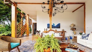 A spacious living room with a wooden staircase, a large fern plant, a white sofa, and a chandelier. - Casa de Campo el Edén (Armenia)