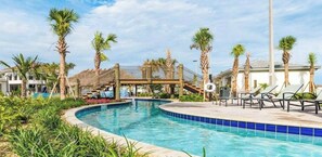 A swimming pool with palm trees, lounge chairs, and a covered area.