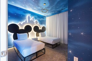 A bedroom with two beds, a nightstand, and a starry ceiling design.