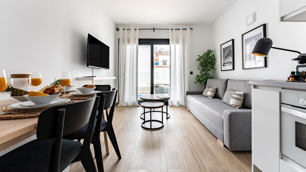 A modern kitchen with a dining area, a sofa, and a TV. - Boutique Apartment in Faro's Fuengirola (Fuengirola)
