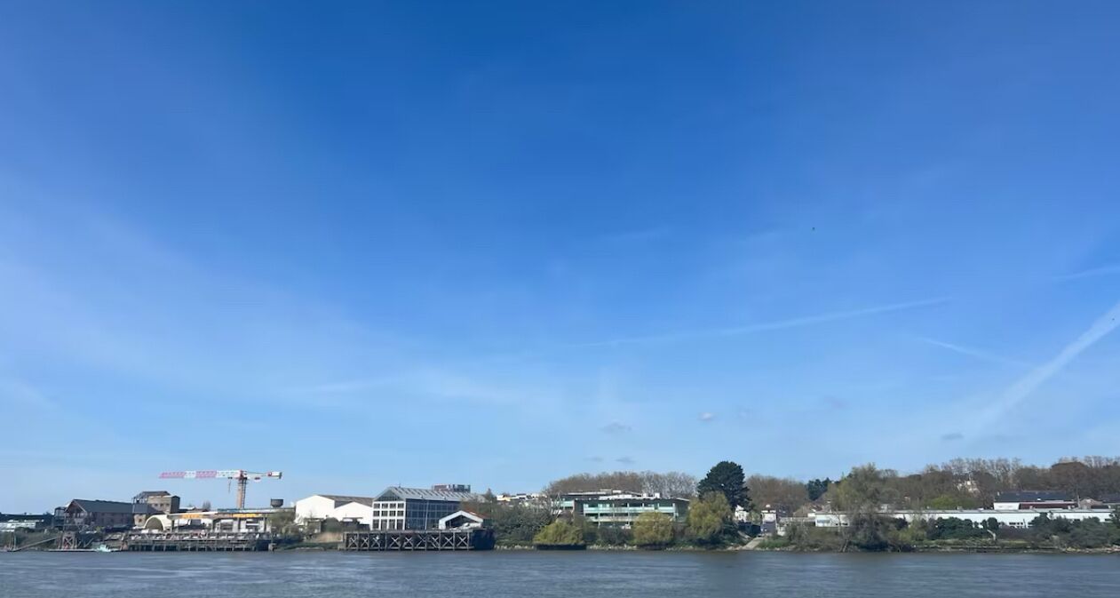 Une vue sur le front de mer, avec des bâtiments, un quai et une grue.