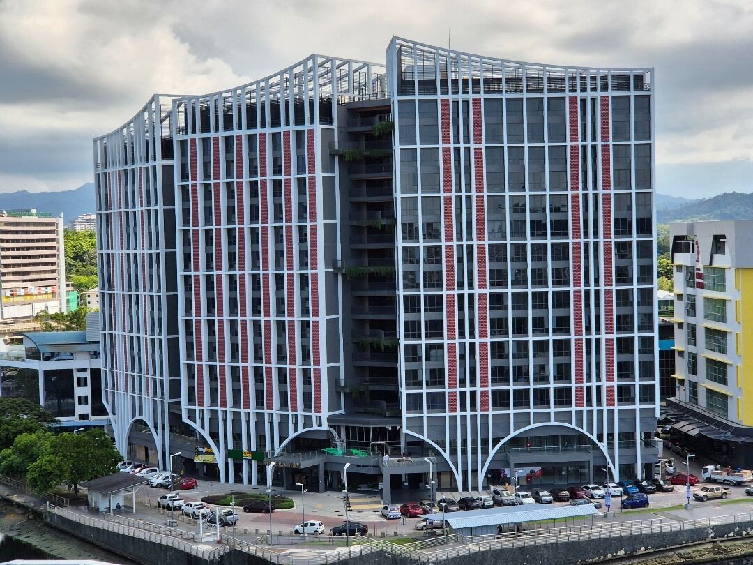 A modern multi-story building with a grid-like facade, large windows, and a curved entrance.