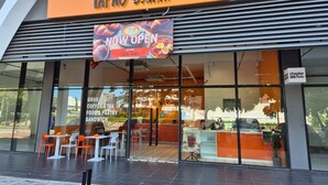 A restaurant named "Tapau Bahnhn" with a 'NOW OPEN' sign, featuring a modern design with glass windows and outdoor seating. - Sutra Bay (Kota Kinabalu)