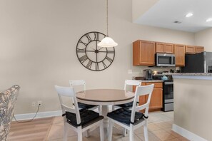 A modern kitchen with wooden cabinets, a microwave, and a refrigerator. - Cozy Barefoot Resort Condo - Pool & Golf (North Myrtle Beach)