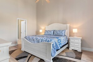 A bedroom with a bed, bedside tables, and a door. - Cozy Barefoot Resort Condo - Pool & Golf (North Myrtle Beach)