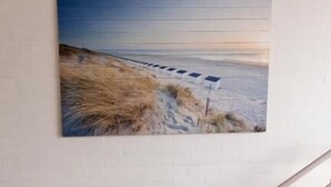 A staircase leading to a room with a beach scene painting on the wall. - Kabine7 (Koksijde)