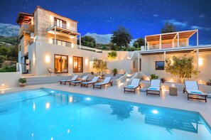 A modern house with a swimming pool, lounge chairs, and a starry night sky. - Soluna Villa Private Pool (Chania)