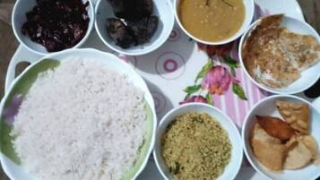 Una bandeja con varios platos, incluyendo arroz, un tazón de sopa y carne.