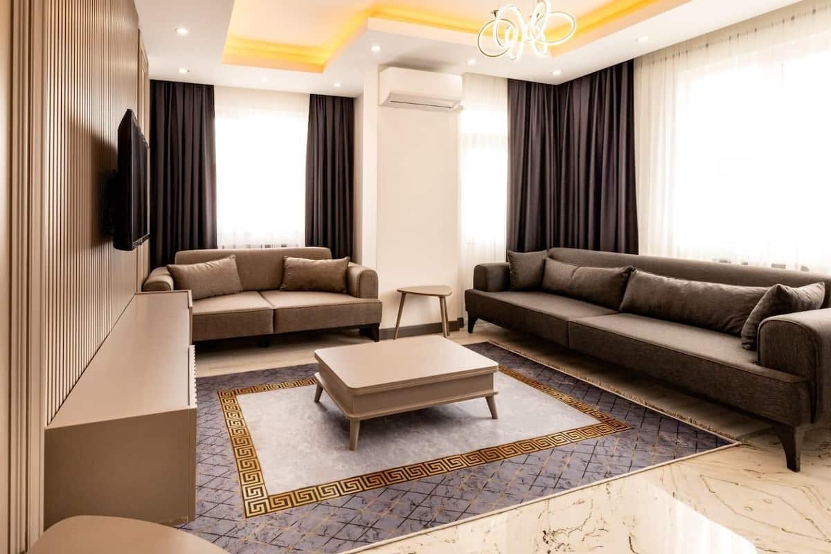 A modern living room with two sofas, a coffee table, and a TV mounted on the wall.