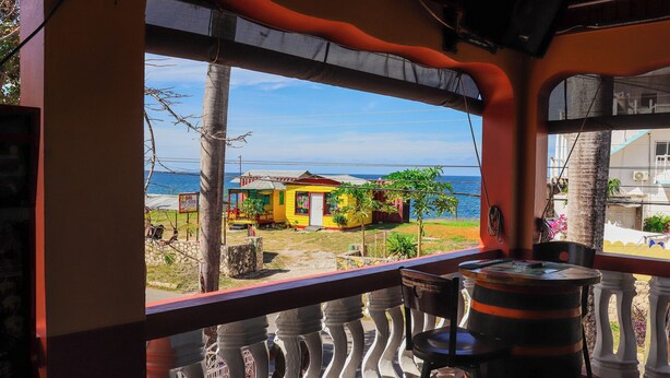 A balcony with a view of a beach and colorful buildings.