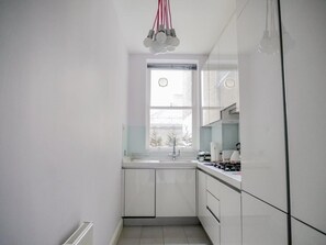 Enjoy cooking in this well-equipped kitchen with a gas stove, stainless steel sink, and ample countertop space.