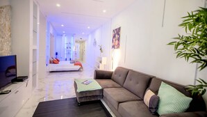 Una sala de estar moderna con un sofá marrón, una mesa de centro y un televisor sobre un mueble.