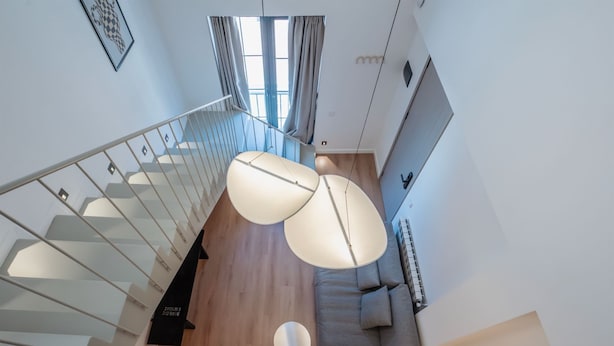 A modern interior with a staircase, a round coffee table, and a sofa. - Artifact Apart Hotel  (Tbilisi)