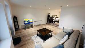 Ein modernes Wohnzimmer mit Sofa, Couchtisch und Fernseher.