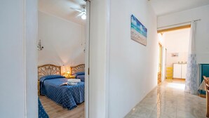 A room with a bed, a desk, and a painting on the wall. - Brezza Apartment With Terrace Near The Sea (Porto Cesareo)