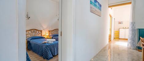 Una habitación con una cama, un escritorio y un cuadro en la pared.