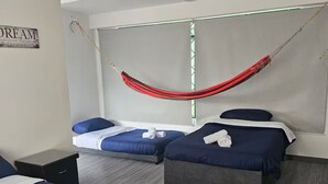 A hotel room with two beds, a hammock, and a wall-mounted shelf. - Loft Type Apartment. Bogotá Concejo (Bogotá)