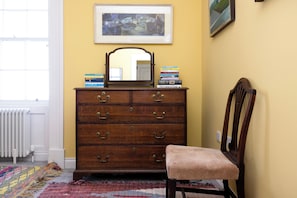 Cozy retreat with a dresser, chair, and window.