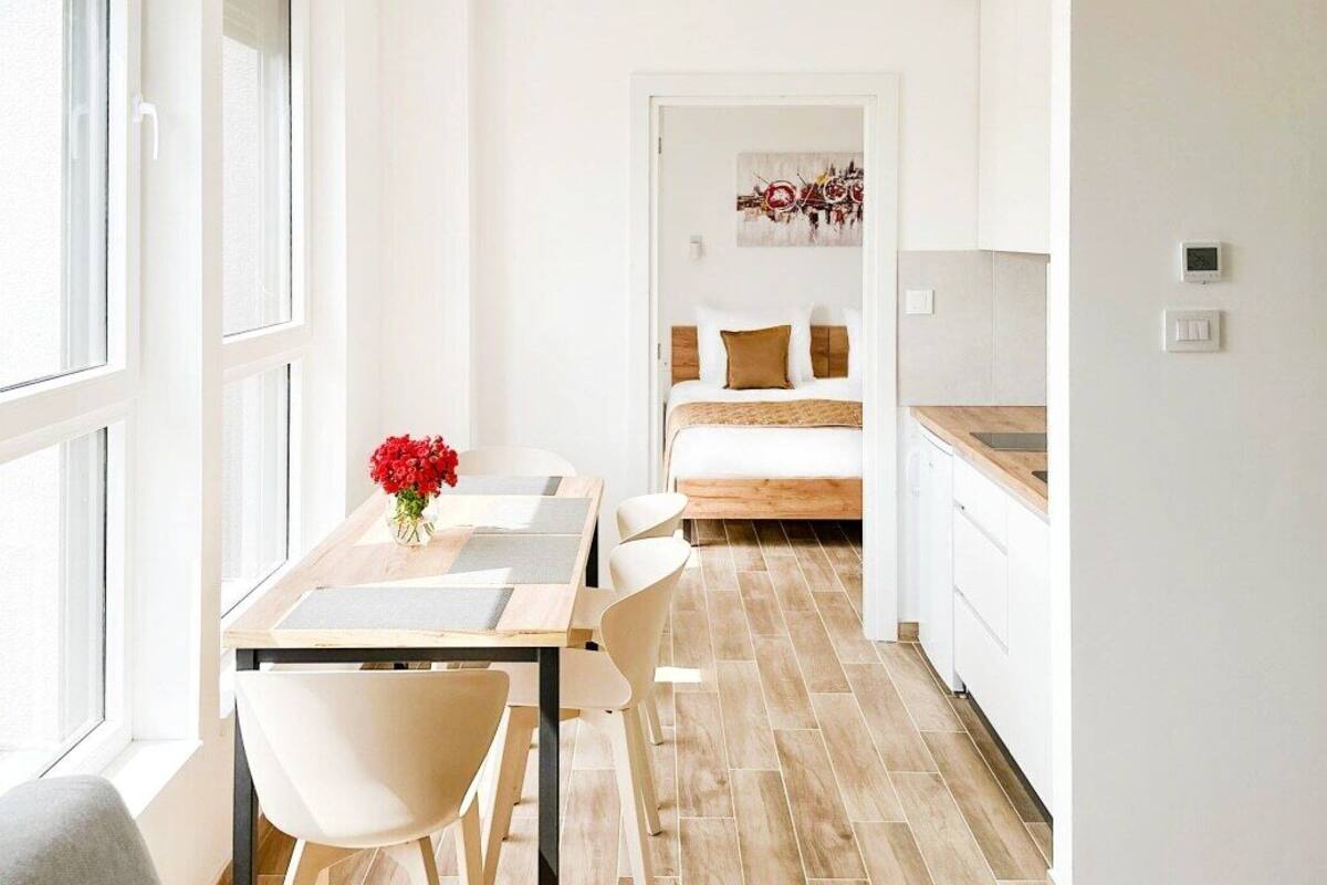 Una habitación moderna y luminosa con comedor, cama y cocina.