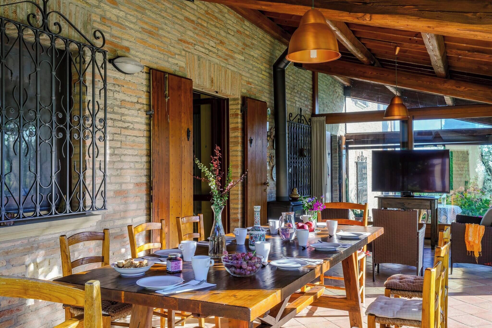 A dining area with a brick wall, wooden furniture, and a TV.