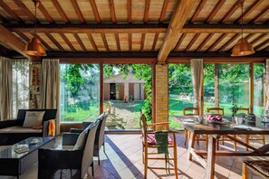 A spacious patio with a dining table, chairs, and a sofa.