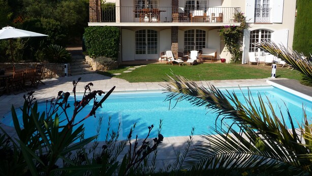 A two-story house with a swimming pool, outdoor furniture, and a well-maintained lawn. - Beautiful house, very well located, sleeps 4 to 10, with swimming pool and air conditioning. (Saint-Raphaël)