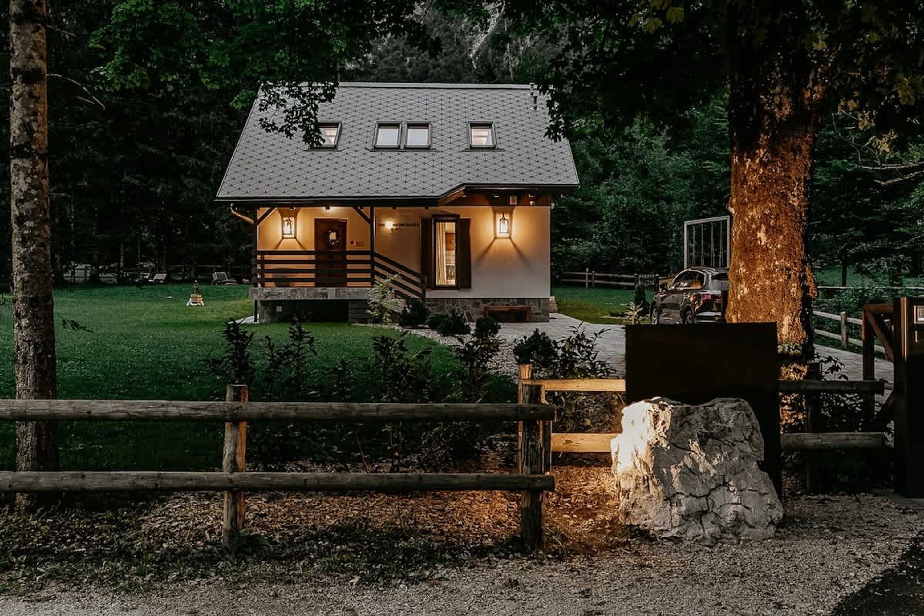Eine kleine, zweistöckige Holzhütte mit Steinfundament, einer Holzdiele und einer Steinmauer.