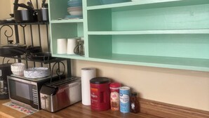 A kitchen with a microwave, toaster, and various kitchen items on the counter.