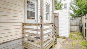 A wooden deck with a gate leading to a house with white siding and a front door. - Cozy 2BR with Bunk Beds, Steps to Boardwalk (Ocean City)