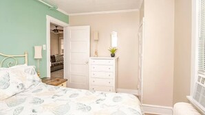 A bedroom with a bed, dresser, and a door leading to another room. - Cozy 2BR with Bunk Beds, Steps to Boardwalk (Ocean City)