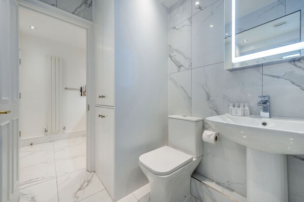 A modern bathroom with a toilet, sink, and shower area.