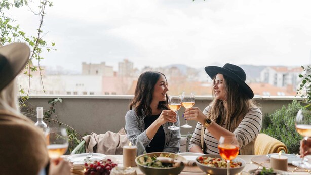 Two people toasting at a table with food and drinks, overlooking a cityscape. - The Aristocrat - Fitzrovia - by Frankie Says (London)