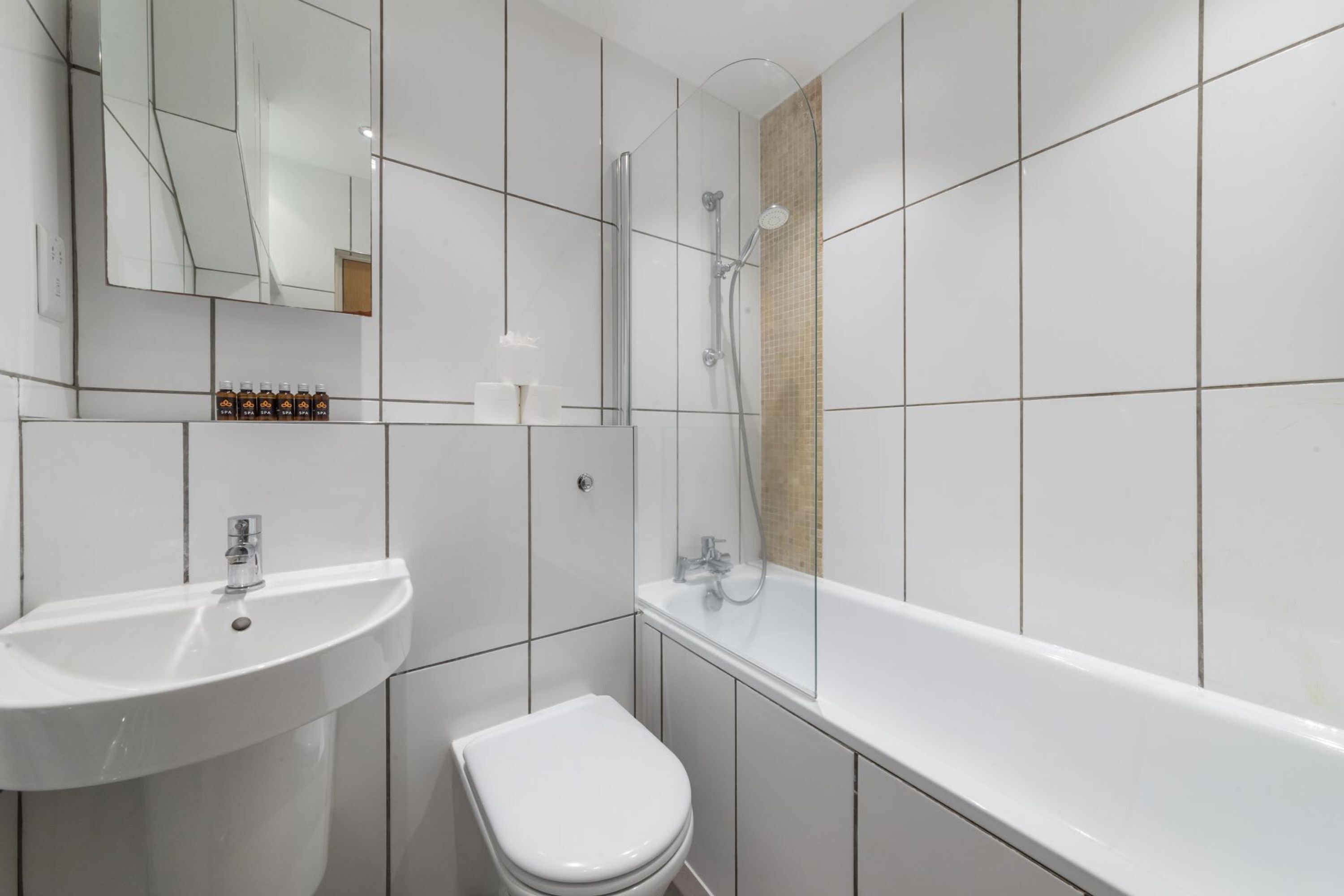 A modern bathroom with a white sink, toilet, and bathtub.