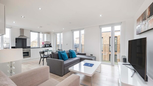 A modern apartment with a living room, dining area, and kitchen. - The Kings Residence - St Pancras - by Frankie Says (London)