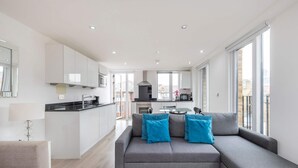 A modern apartment with a kitchen, dining area, and living room. - The Kings Residence - St Pancras - by Frankie Says (London)