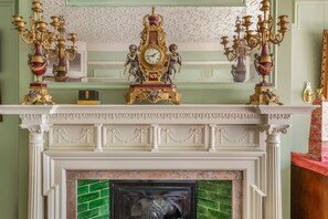 A fireplace with a clock and ornate candelabras. - The Grand Old Boy - Marylebone - by Frankie Says (London)