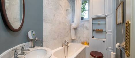 A bathroom with two sinks, a bathtub, and a toilet.